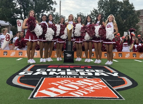 ESPN College Gameday featuring cheerleaders on the turf with "ESPN College GameDay" and "The Home Depot"